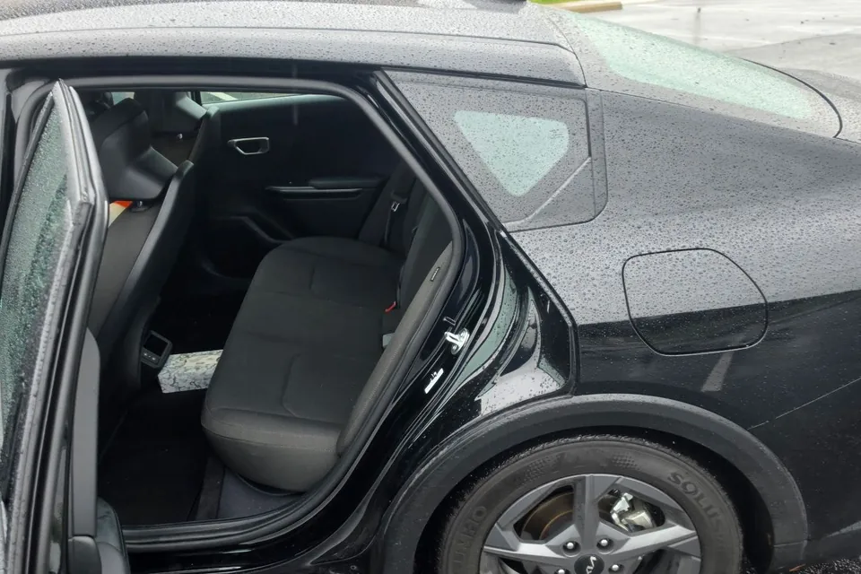 A black ReliaWheels sedan with its rear door open, showing the back seat