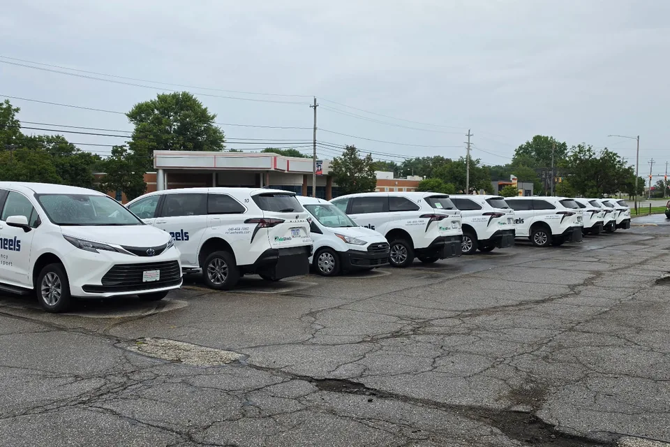 A row of white ReliaWheels wheelchair-accessible vans parked in a lot