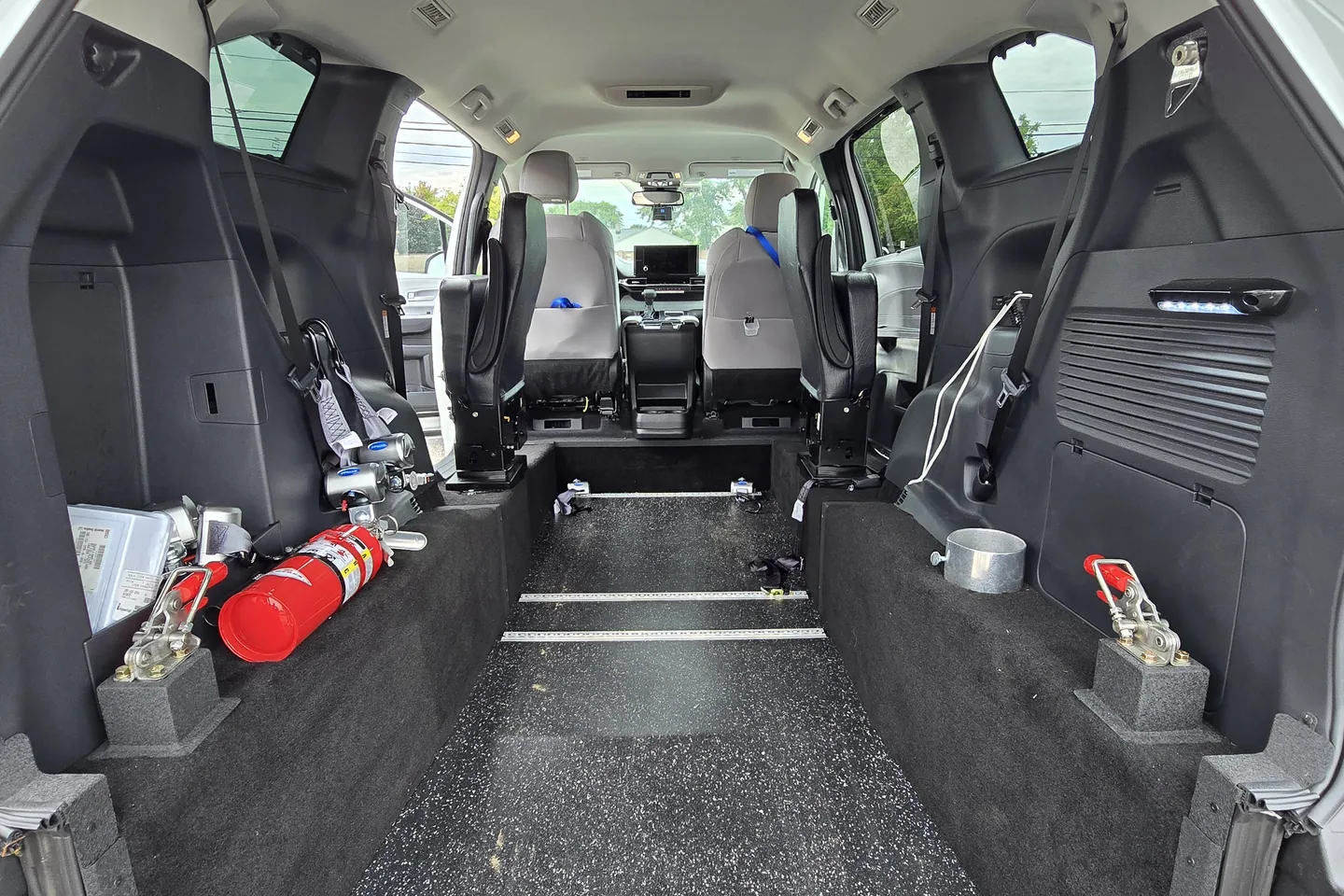 Inside a ReliaWheels van, showing the securement track, fire extinguisher and first aid equipment