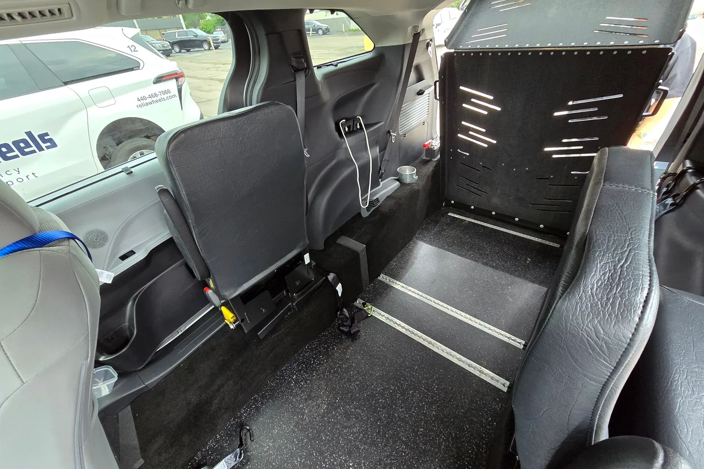 Inside a ReliaWheels van: a seat folded away to open floor space with wheelchair securement tracks