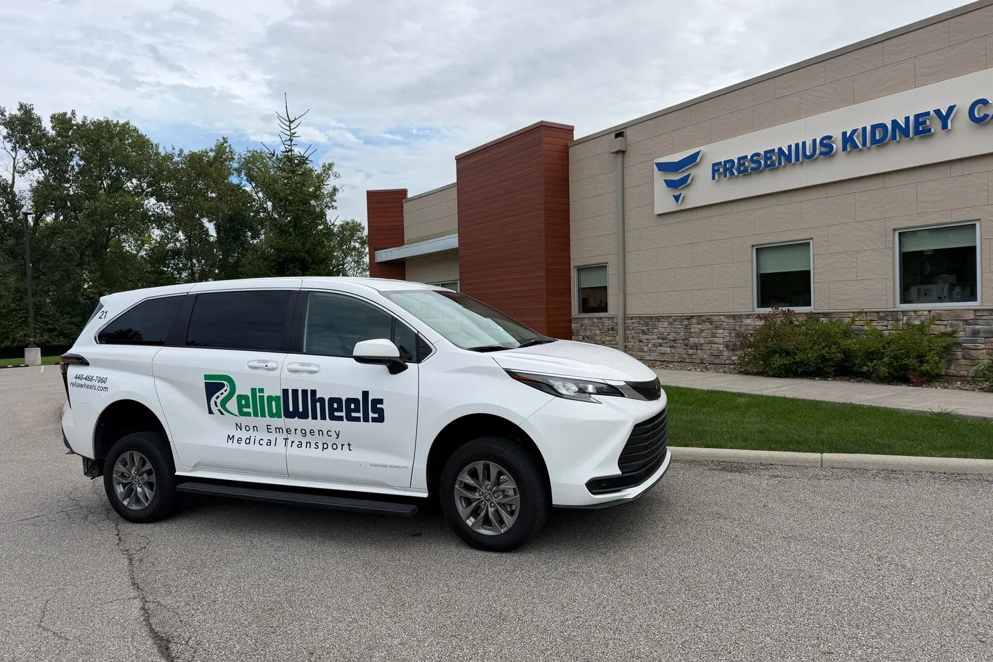 A white ReliaWheels wheelchair van parked outside a Fresenius Kidney Care center