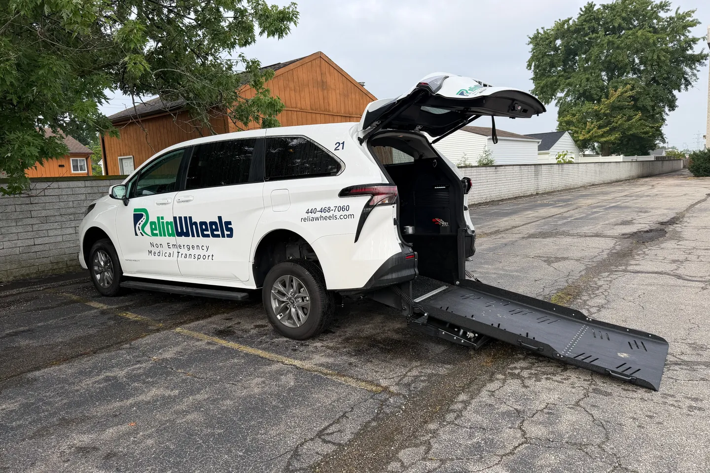 A ReliaWheels wheelchair van with its rear hatch up and the ramp lowered to the ground