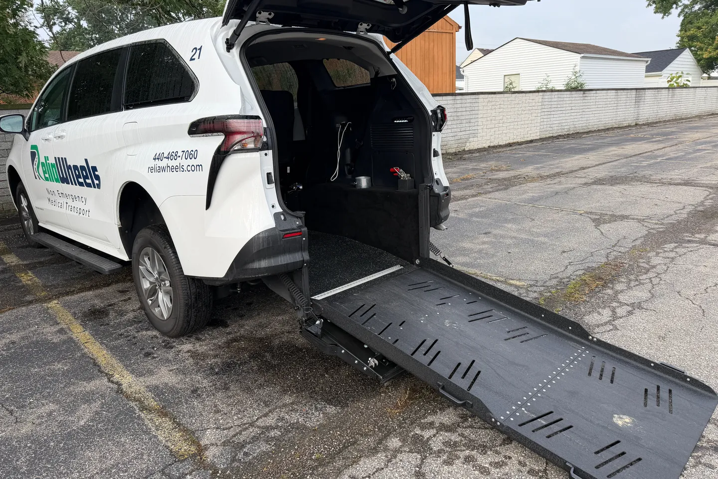 A ReliaWheels van seen from behind with its rear hatch open and wheelchair ramp lowered