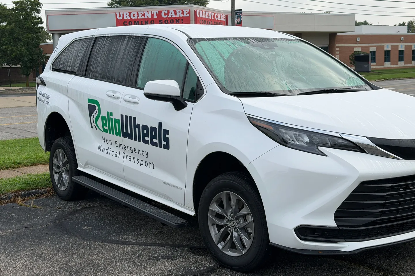 A white ReliaWheels wheelchair van parked outside an urgent care building